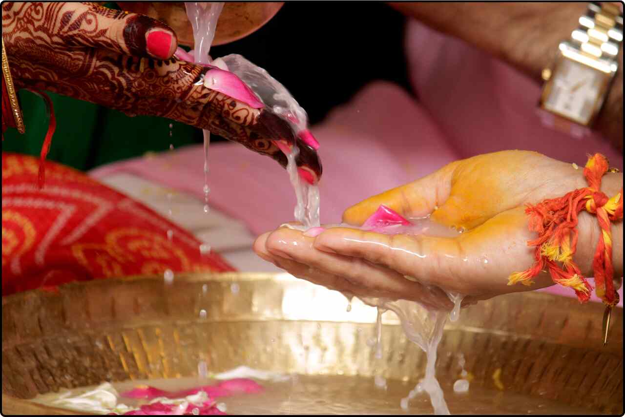 Close-up of the Indian bride and groom holding hands, showcasing their traditional wedding.